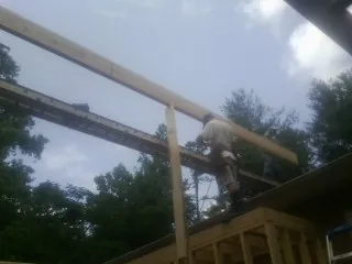 Carpenter setting a ridge beam over a new addition frame — Ice Dam Removal by Roofing Brothers in Emeryville