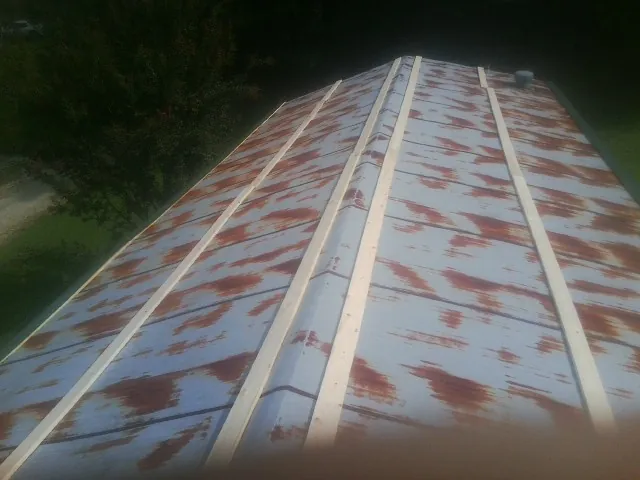 Rusted metal roof panels with new wood purlins before replacement — Storm Damage Roof Repair in Emeryville by Roofing Brothers