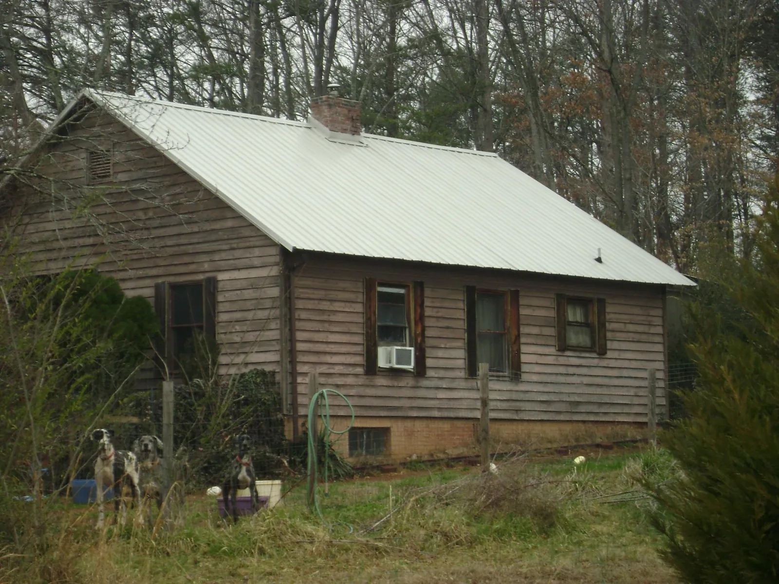 White metal roof on an old wood sided farmhouse, from a Metal Roof Installation job in Emeryville
